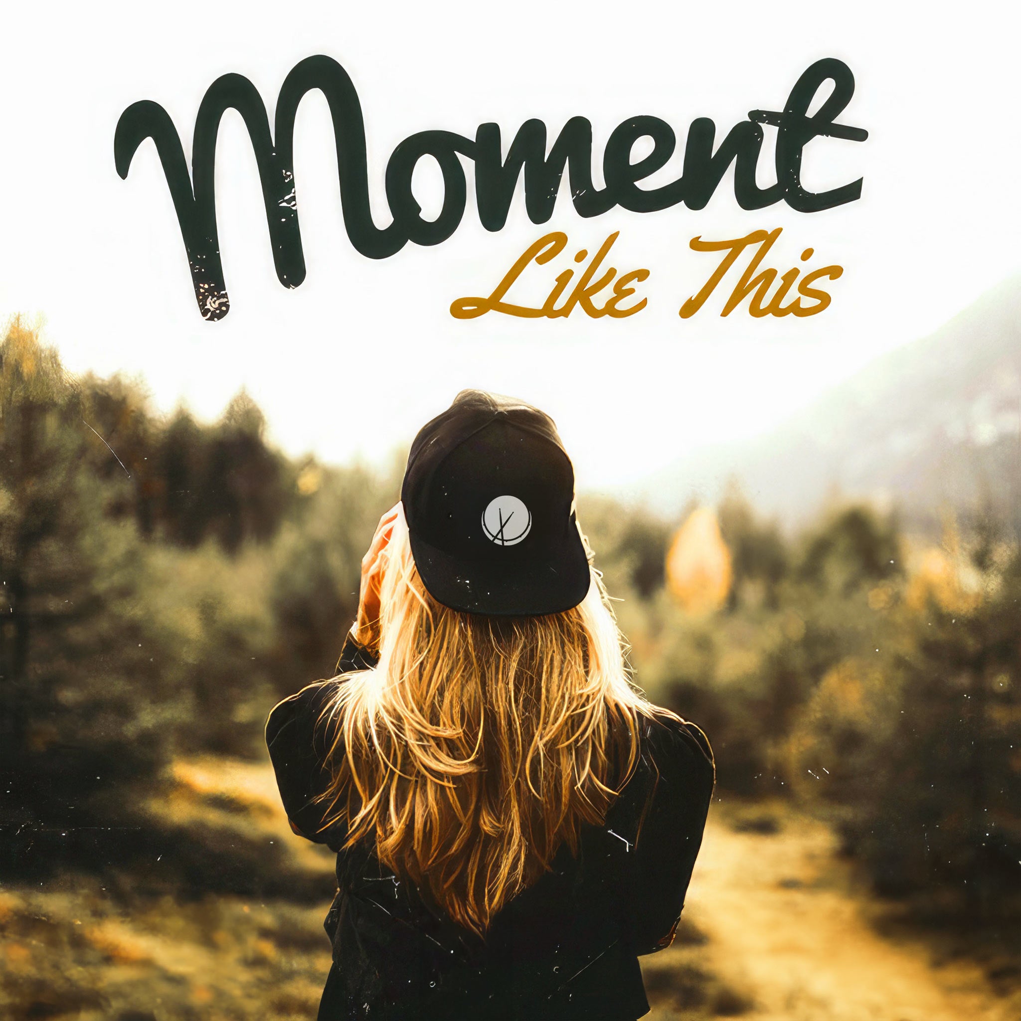 A serene and contemplative image portraying the essence of a "Moment Like This." The scene features a blonde woman wearing a backwards baseball cap, facing towards a lush, naturesque landscape with a dense forest. The composition captures her peaceful connection with nature, suggesting a moment of introspection and tranquility. The surrounding greenery and the natural environment emphasize a sense of calm and reflection, aligning with the theme of appreciating quiet, personal moments.