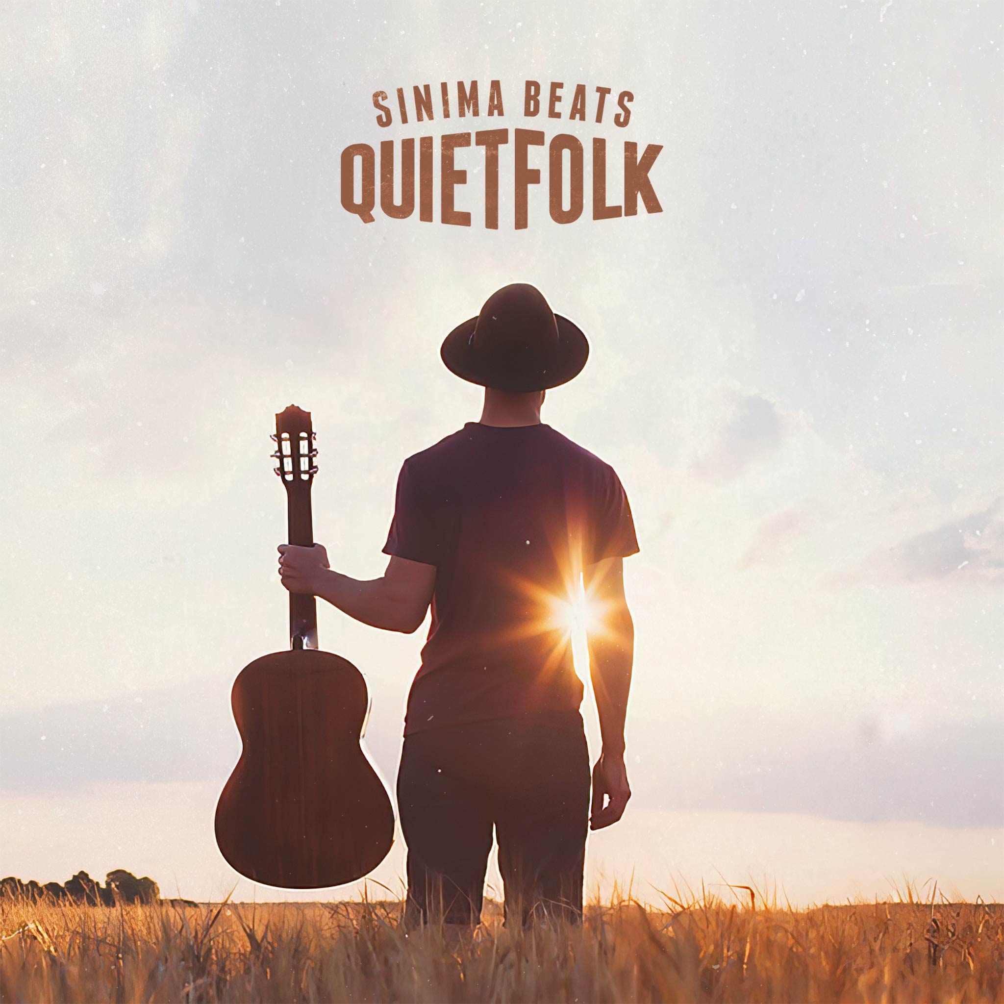 Southern Man Wearing Hat Standing in a Field of Wheat While Holding an Acoustic Guitar Looking Towards the Sun on a Sunny Day. Title: "Quiet Folk."